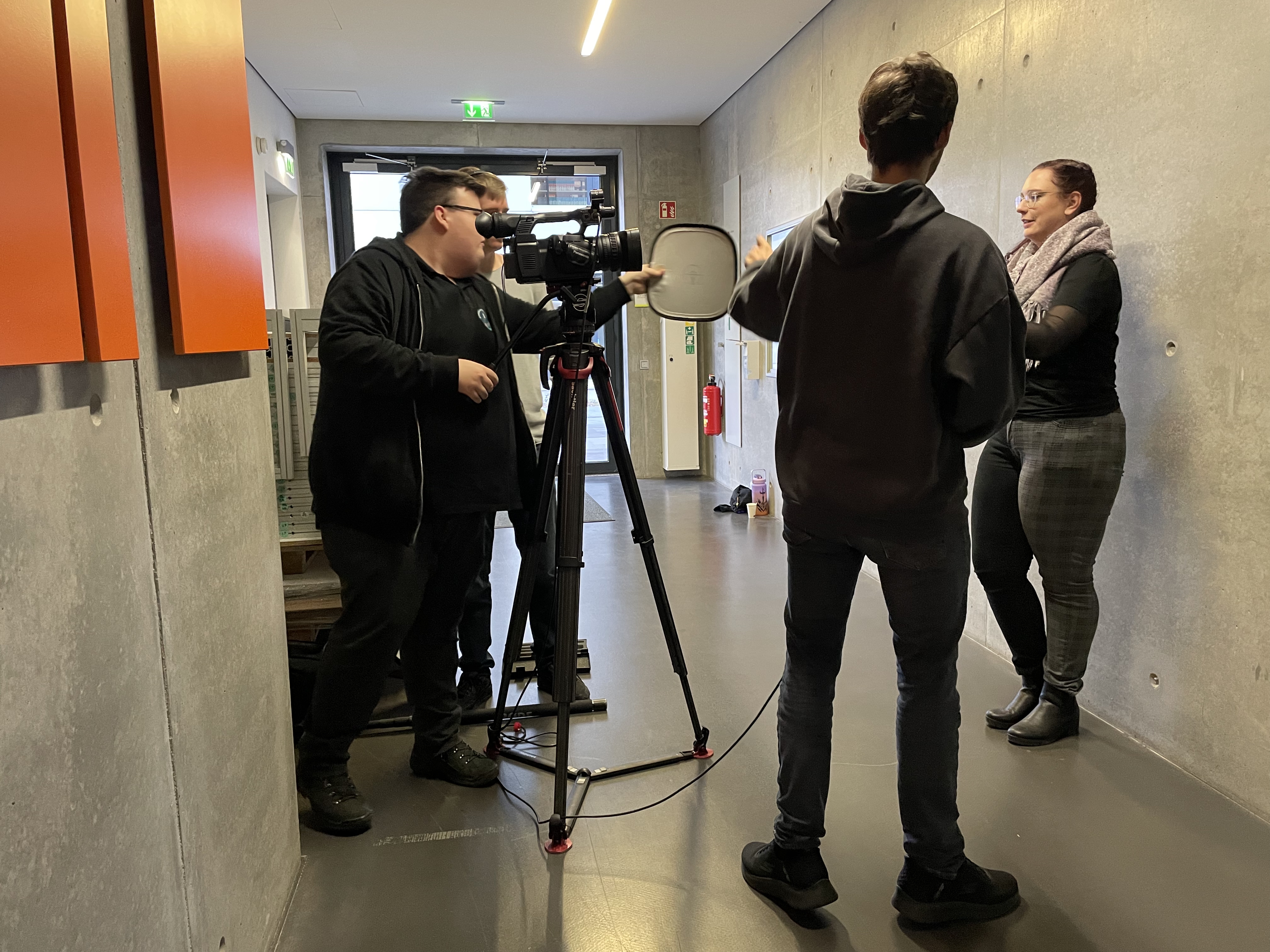 Einblick in eine Videoaufnahme durch ein dreiköpfiges Kamerateam und eine Darstellerin.
