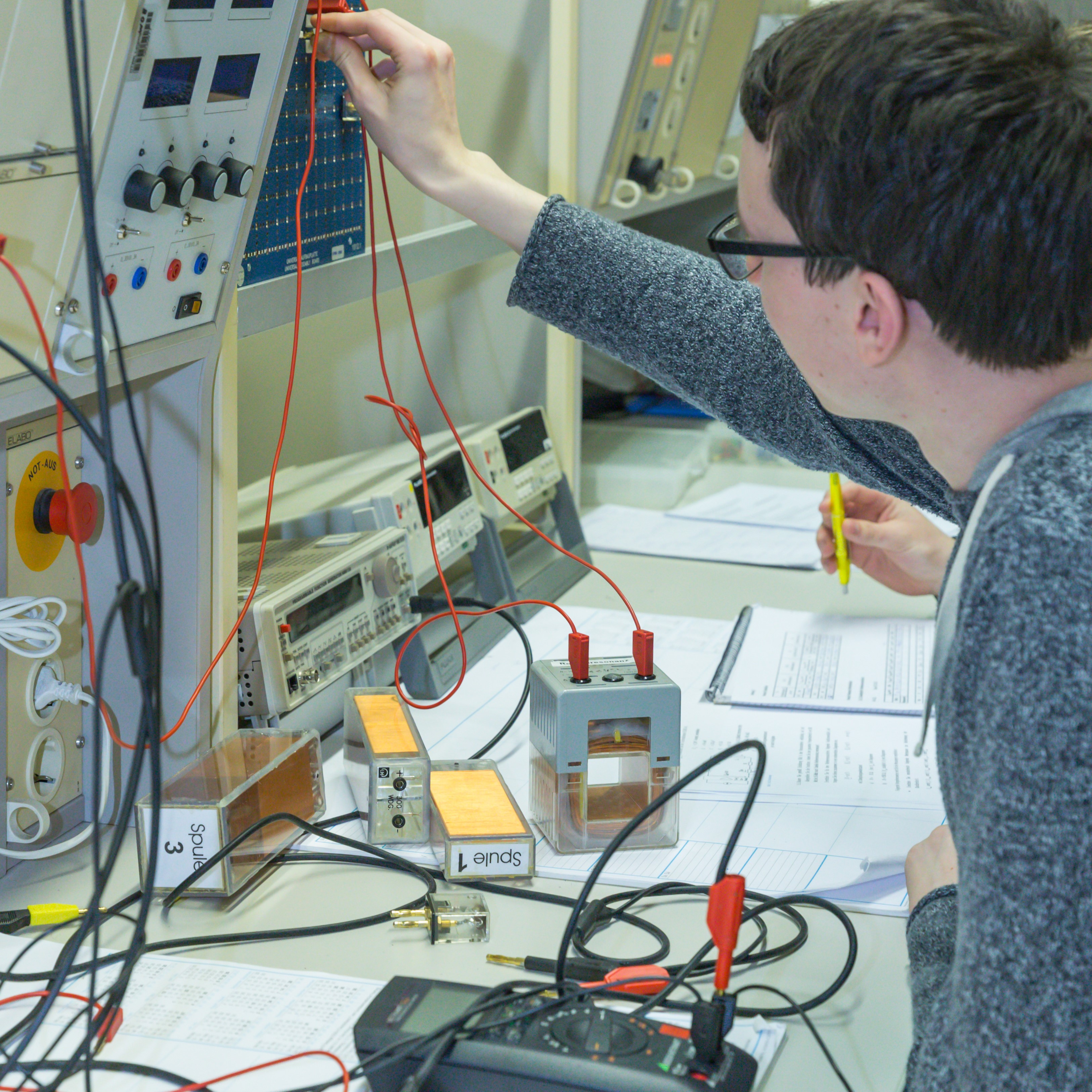 Ein Student misst an einer Spule die elektrische Spannung.