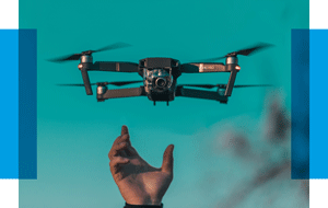 Foto einer kleinen Drohne, die von einer Hand in die Luft gehoben wird.