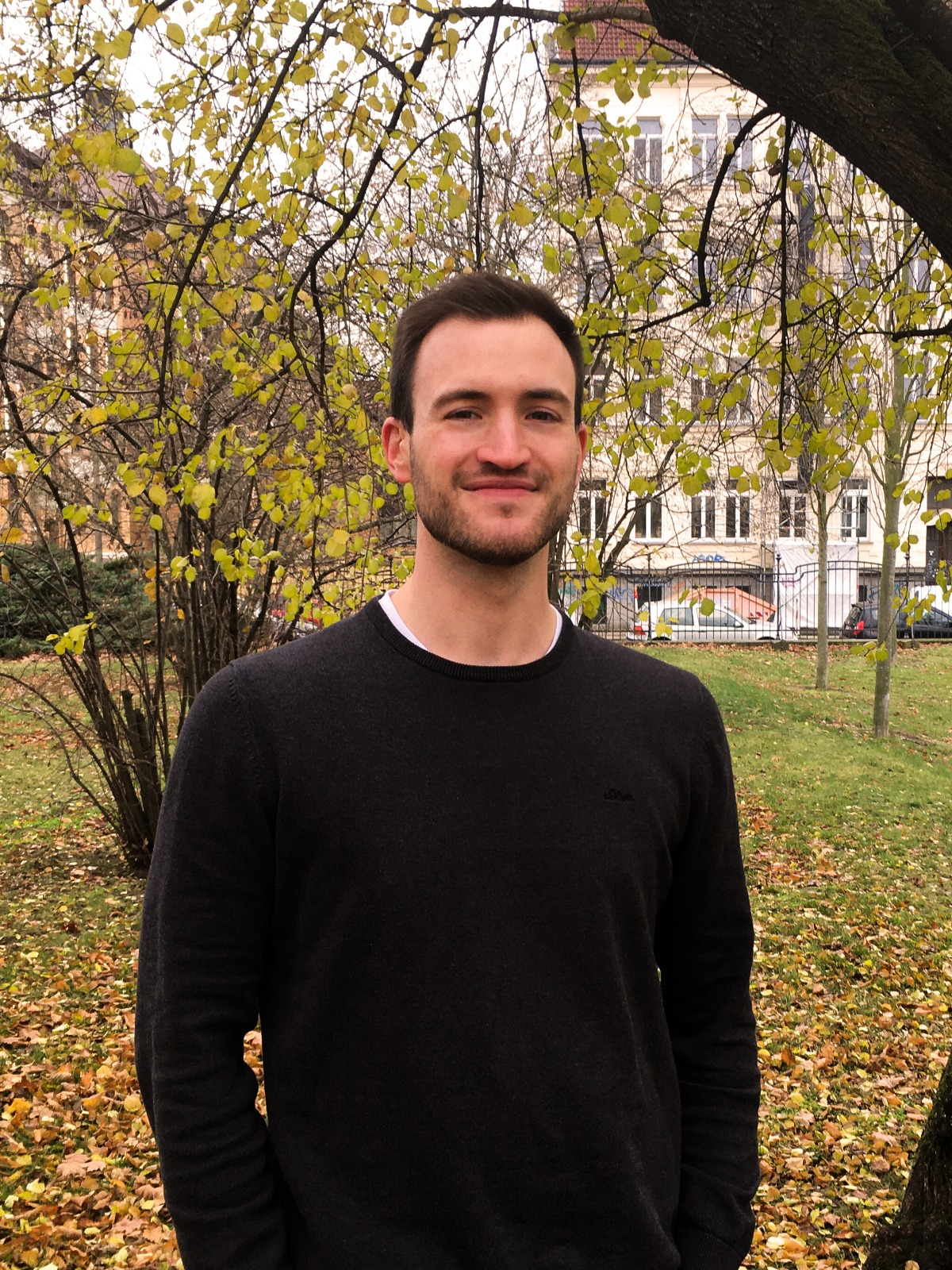 Thomas Miller Thomas steht lächelnd in einem herbstlichen Leipziger Park