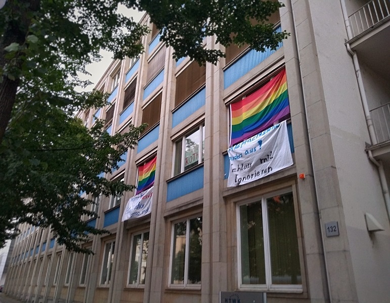 Gehisste Regenbogenfahnen vor dem Fenstern des StuRa-Büro.