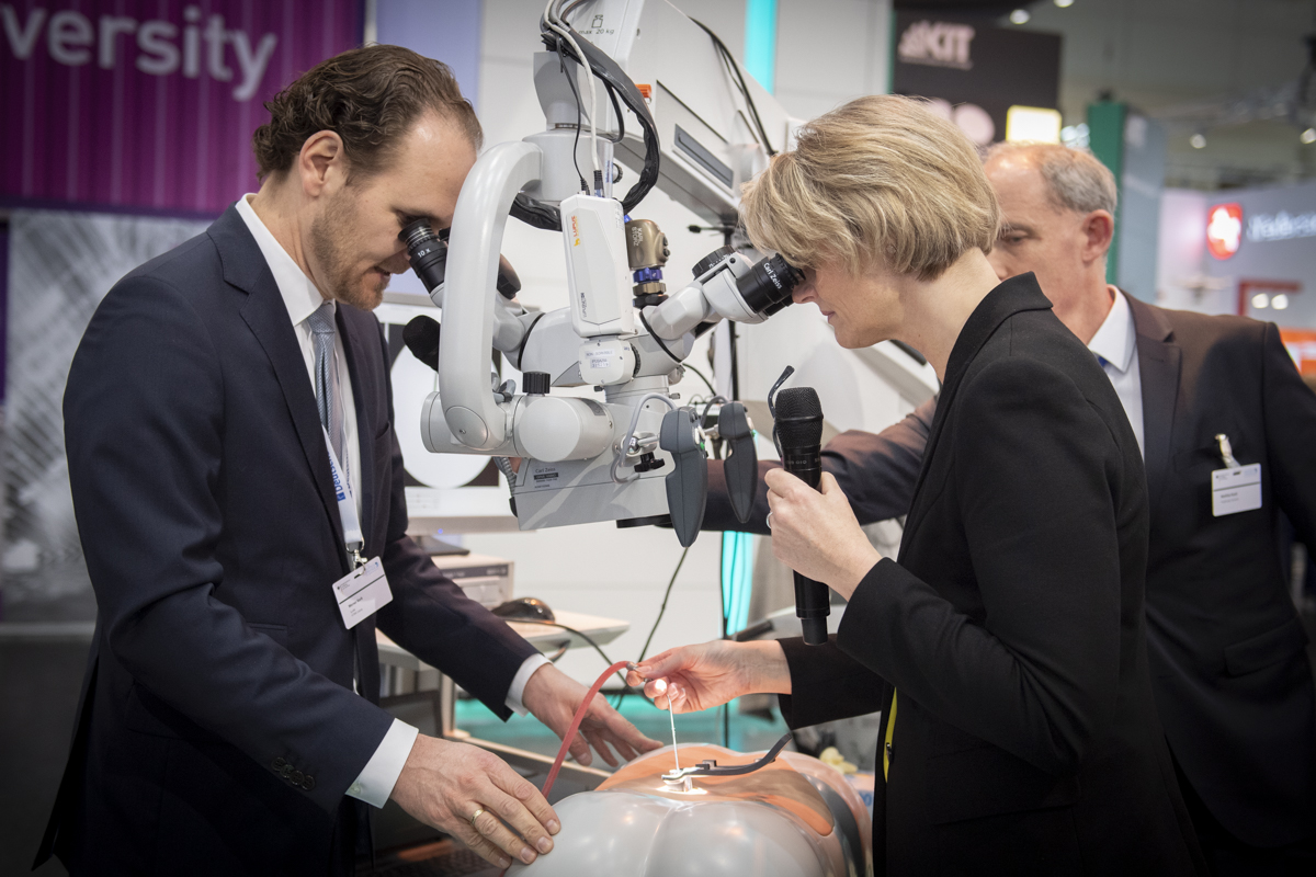 Prof. Werner Korb und Bundesforschungsministerin Anja Karliczek probieren das Gerät bei der Hannover Messe 2019 aus