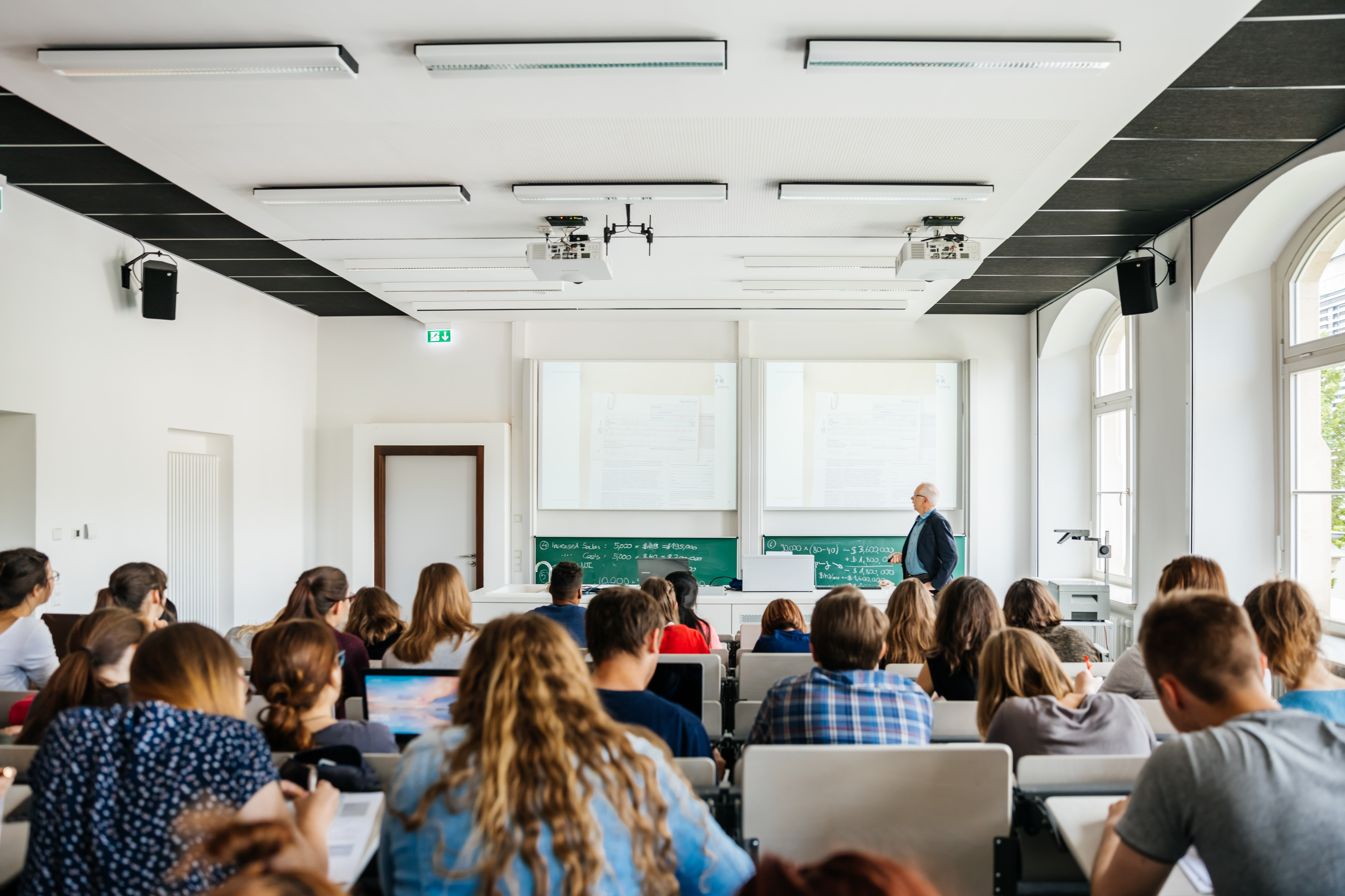 (Foto: feinesbild.de) Studierende sitzen im Hörsaal und folgen einer Vorlesung