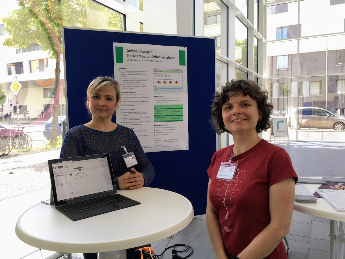 Zwei Frauen an Stand vor Poster