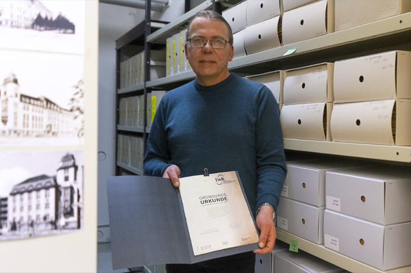 Hochschularchivar Benjamin Schäf mit dem wertvollen Fund. (Foto: HTWK Leipzig) Mann hält Dokument in Kamera