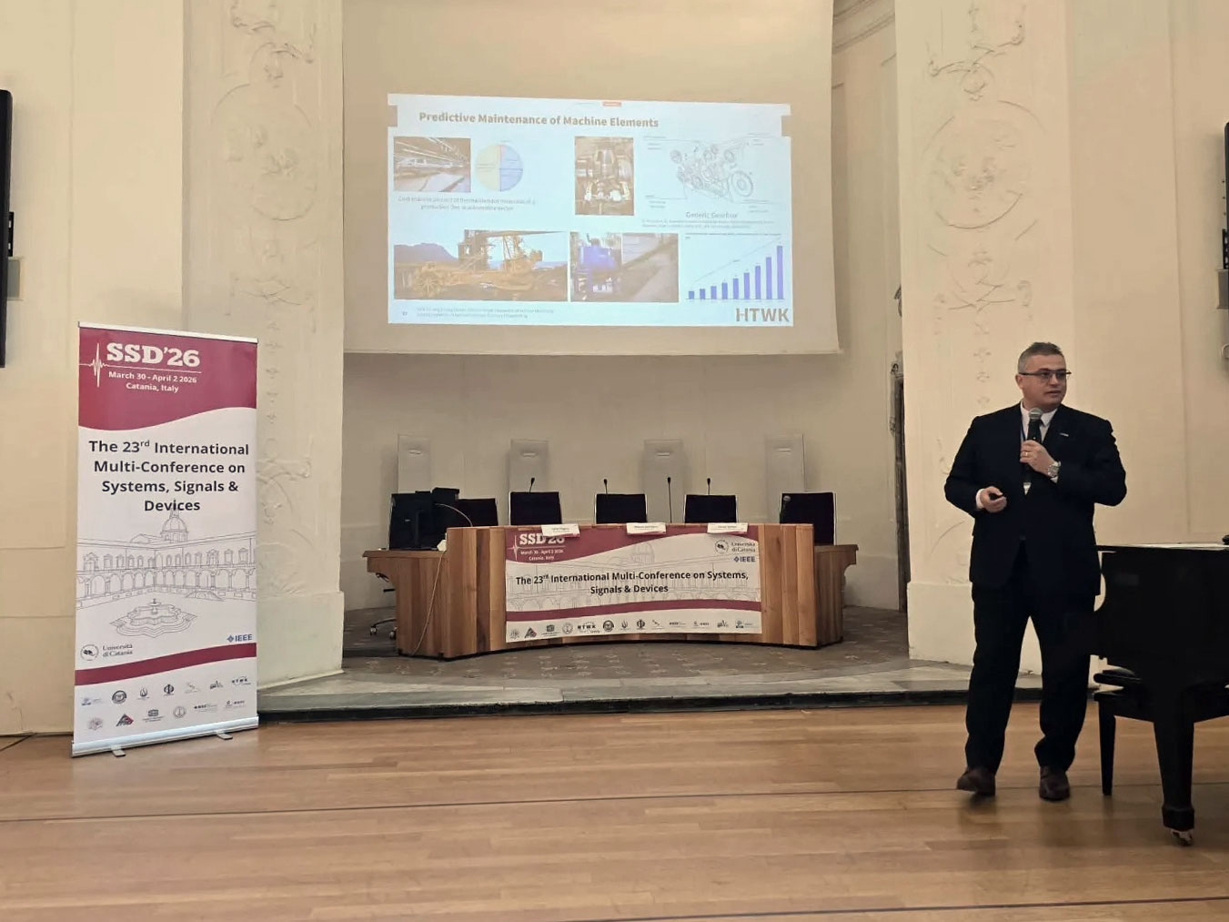 Vortrag Derbel SSD ein Mann steht auf einer Bühne und hält einen Vortrag